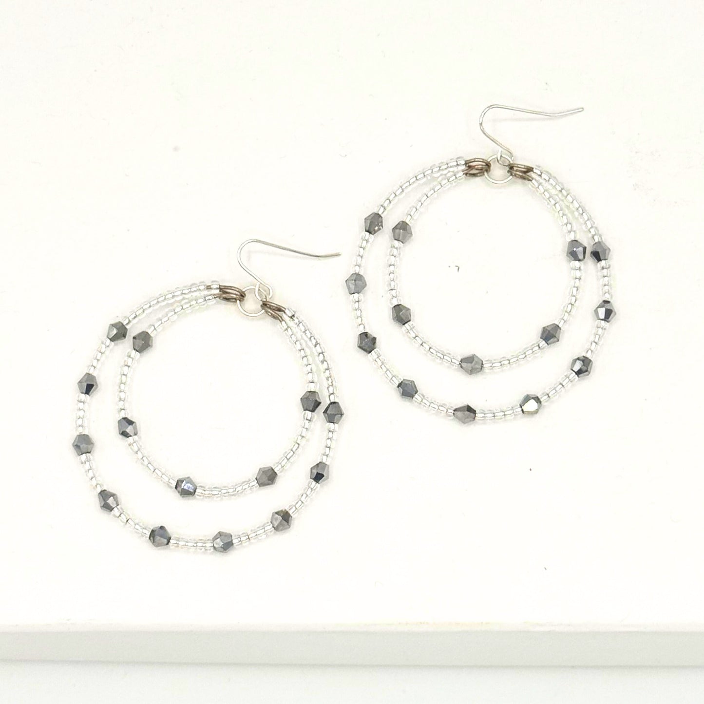 Pair of hoop earrings with beaded design on a white background