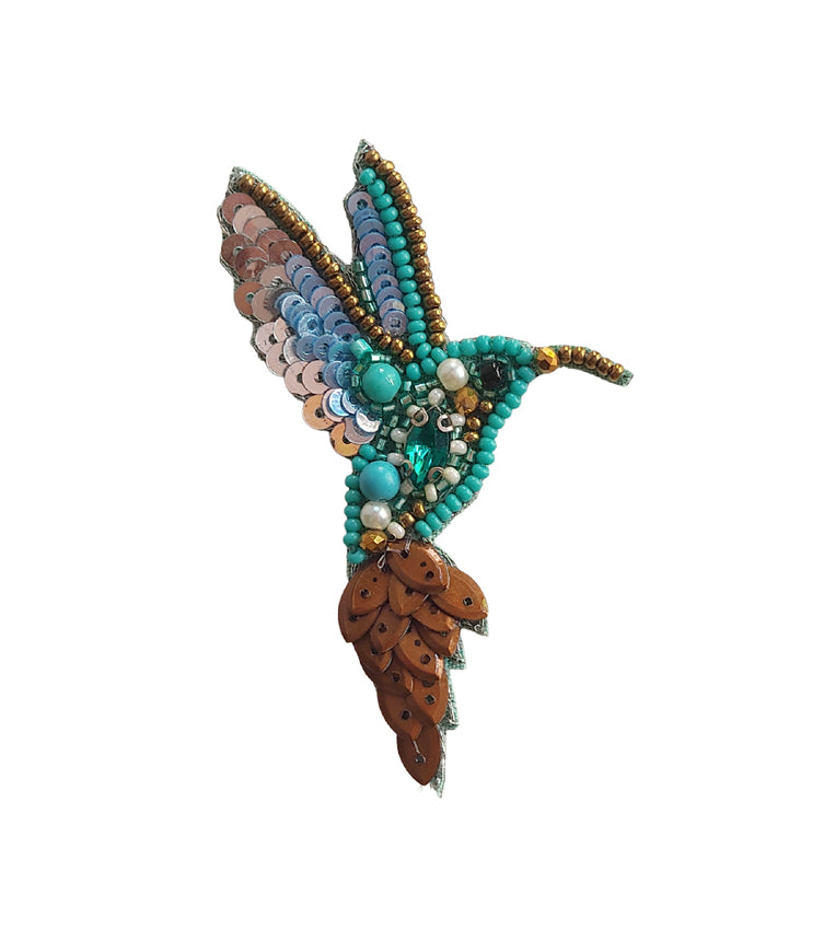 Colorful beaded hummingbird brooch on a white background