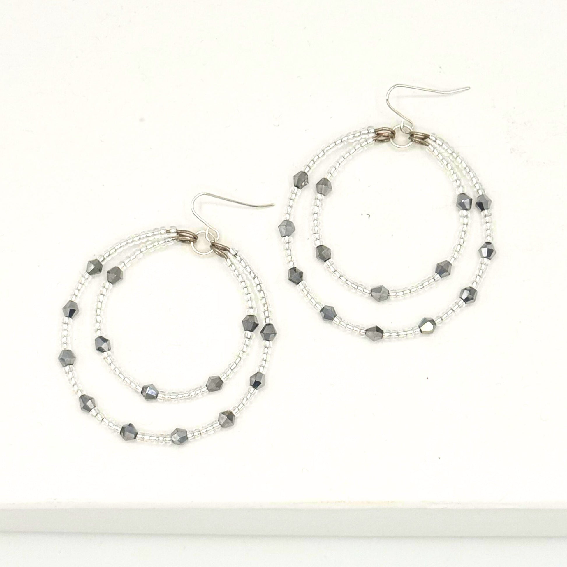 Pair of hoop earrings with beaded design on a white background